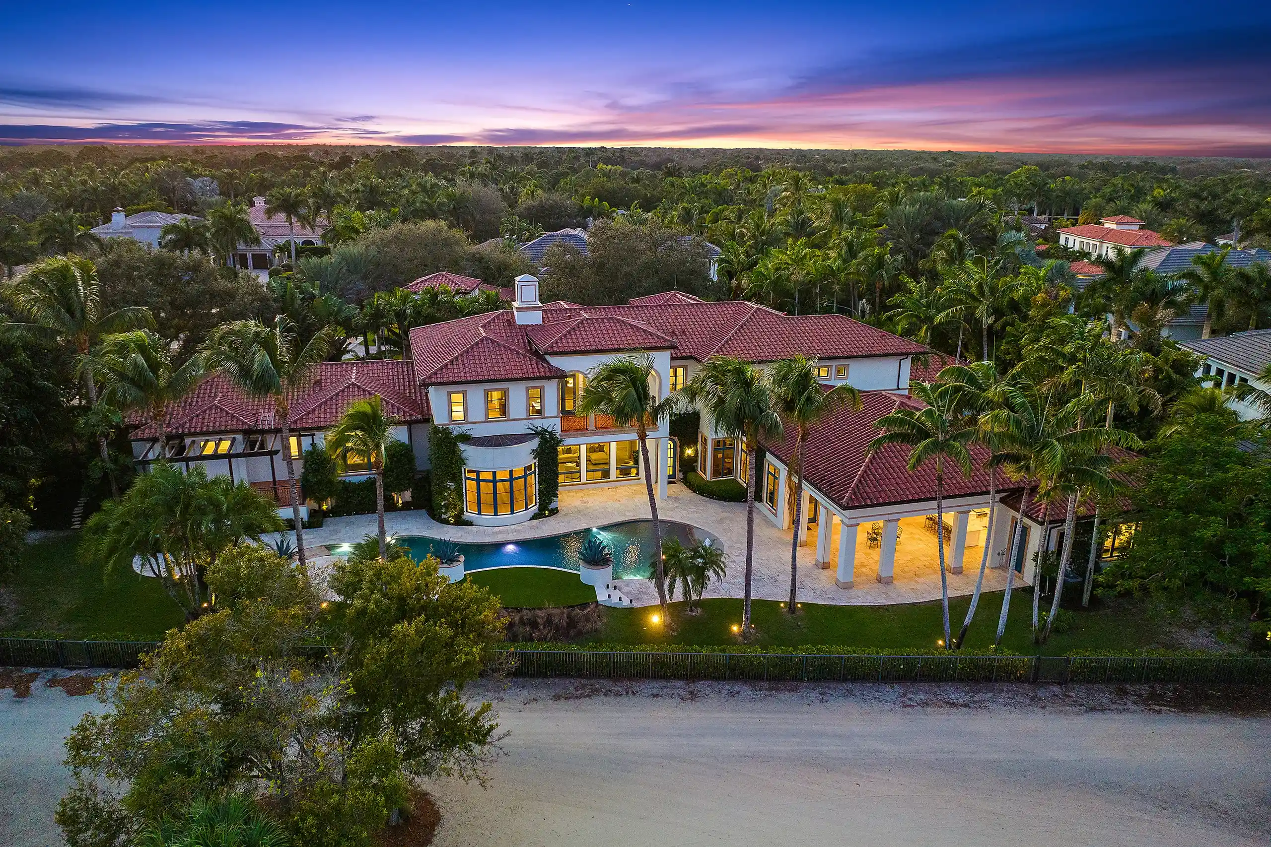 Elevated view of a high-end New Mediterranean style full estate renovation amidst palm trees.