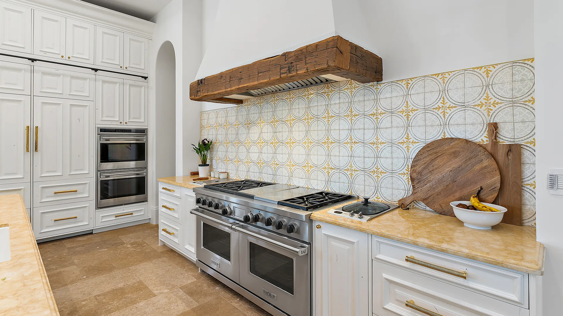 Kitchen design featuring refined gold, grey, and white accents.