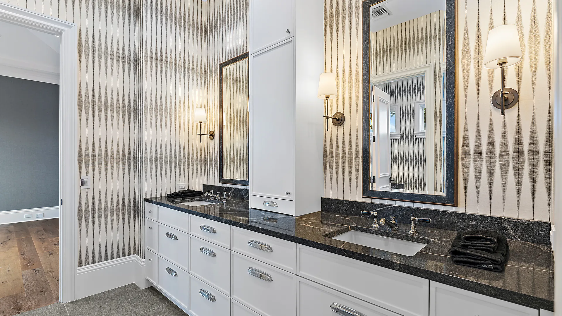 Chic bathroom featuring a double sink with black textures, elegantly framed by a mirror and set against white walls.