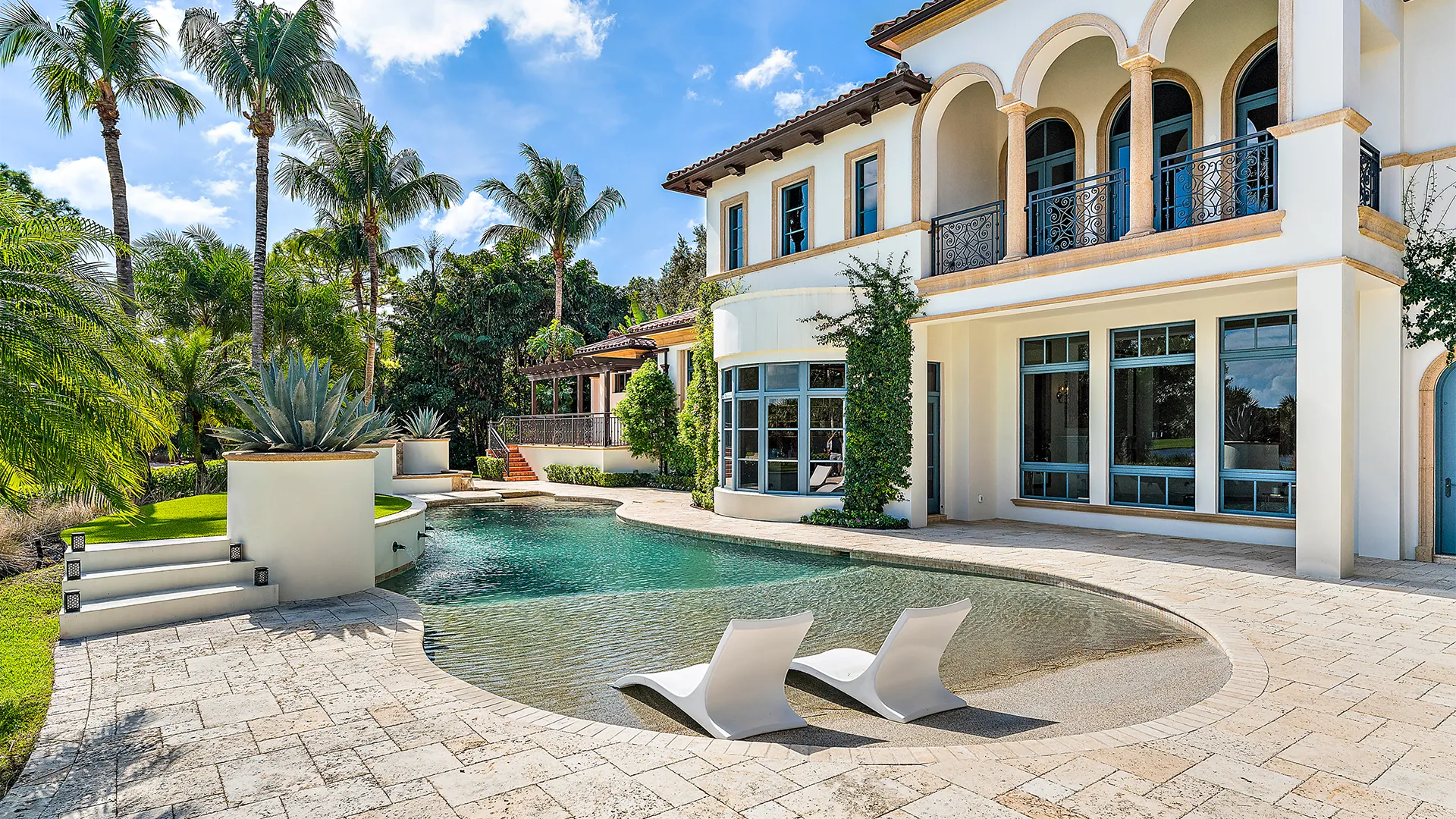 Expansive New Mediterranean style residence with a stunning pool and chic patio, embodying a sophisticated oasis for leisure and gatherings.