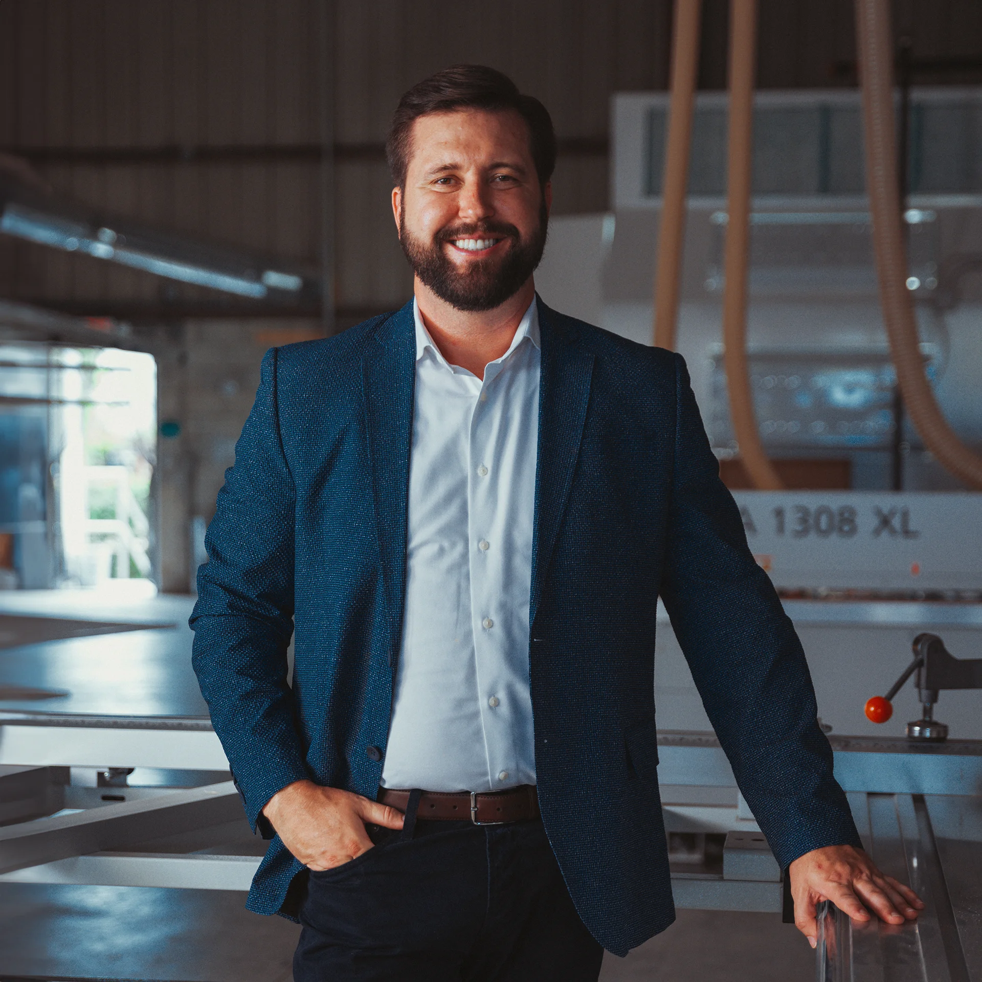 Portrait of Matthew Caldwell in a navy blazer inside the workshop.