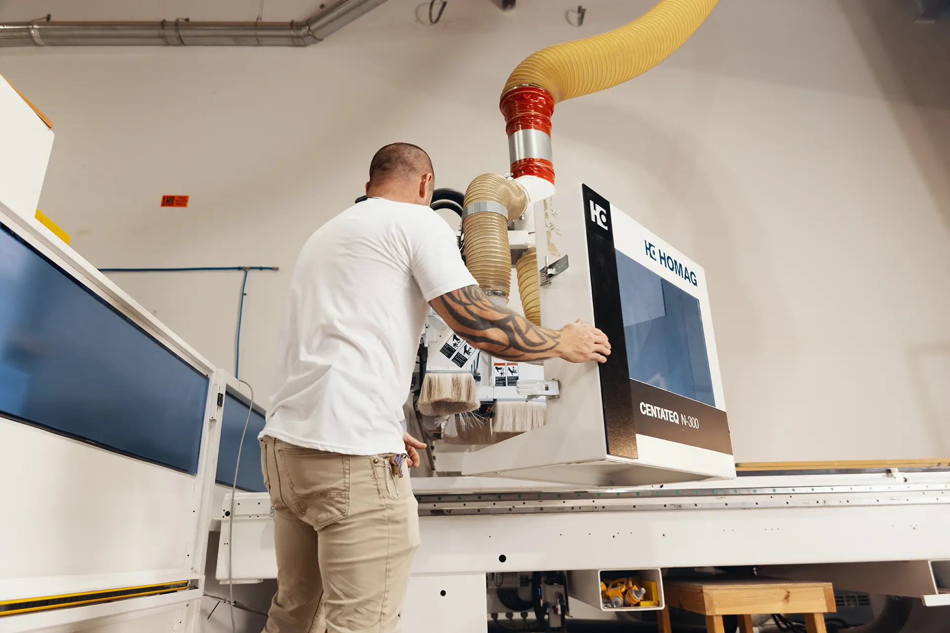 Man with his back turned to camera, diligently works on a machine in the workshop.