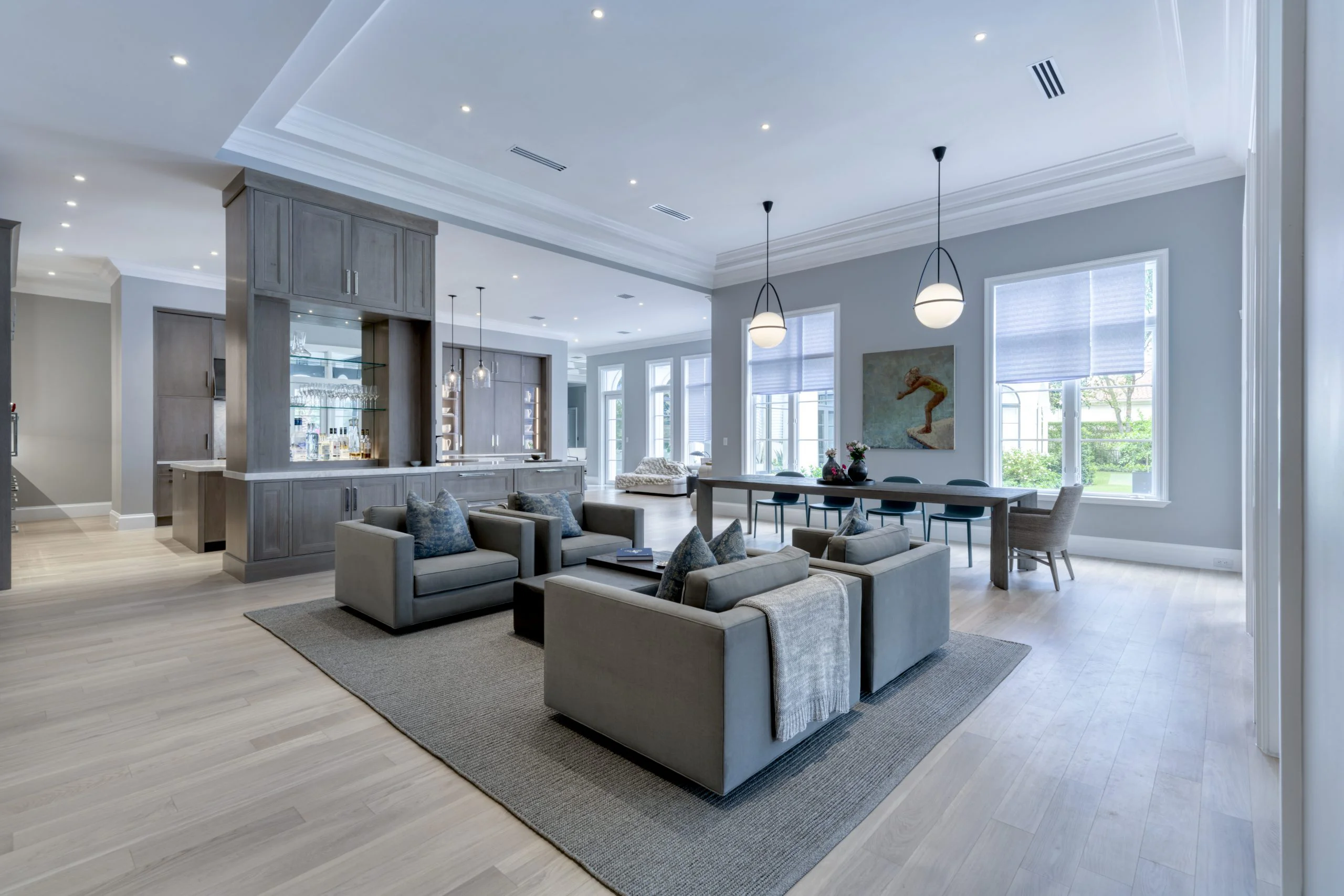Sleek modern living room adorned with gray furnishings, adjacent to a well-designed kitchen space.