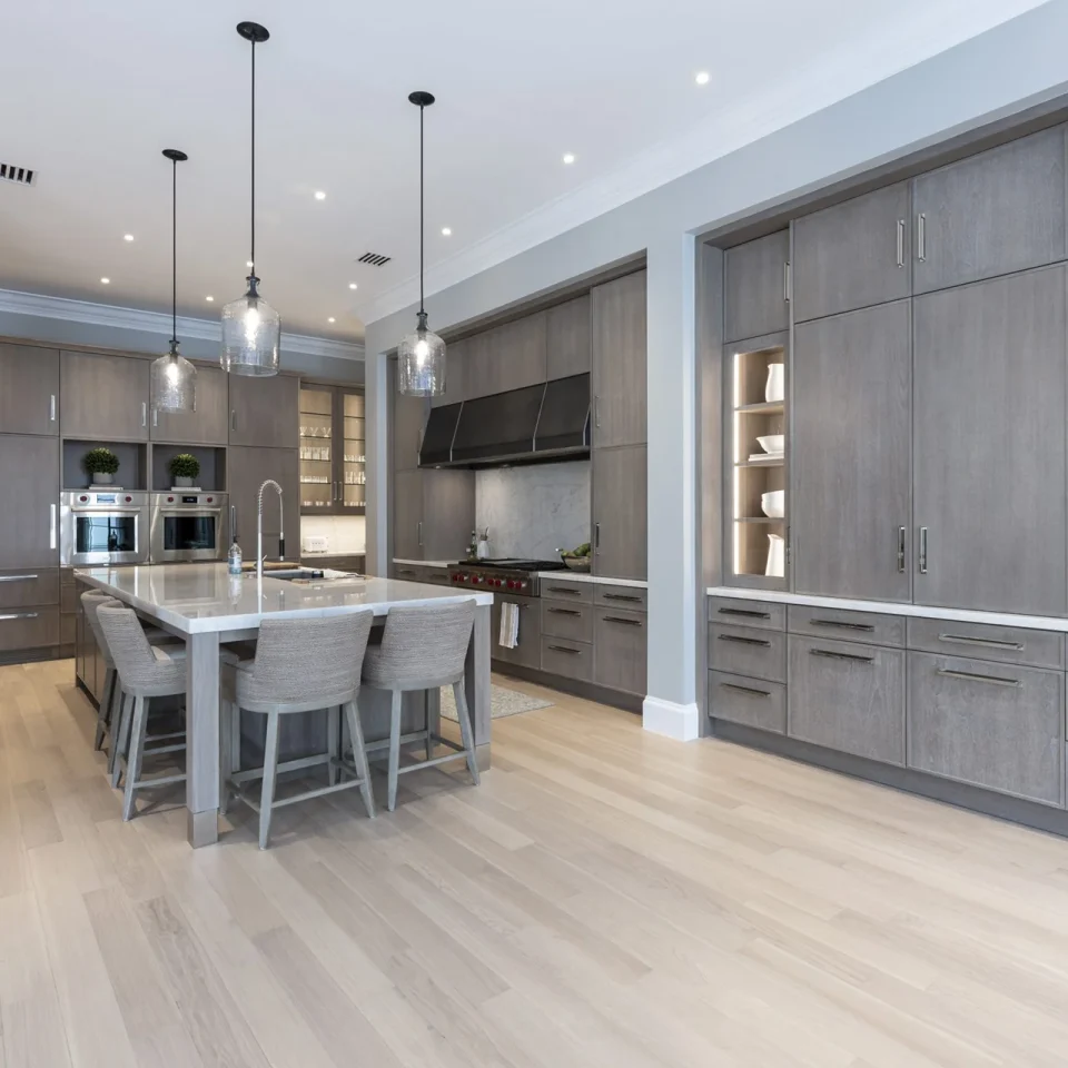Contemporary kitchen with gray cabinetry and a central island, emphasizing style and practicality in a spacious layout.