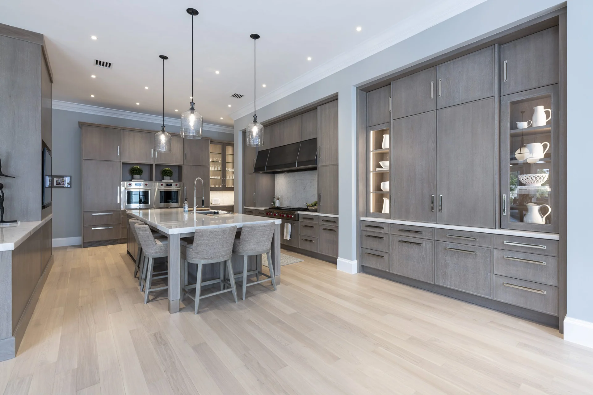 Contemporary kitchen with gray cabinetry and a central island, emphasizing style and practicality in a spacious layout.