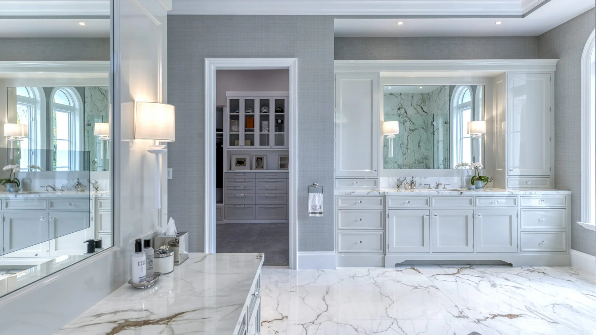 Expansive bathroom with stylish marble countertops and bright white cabinets, reflecting a contemporary design aesthetic.