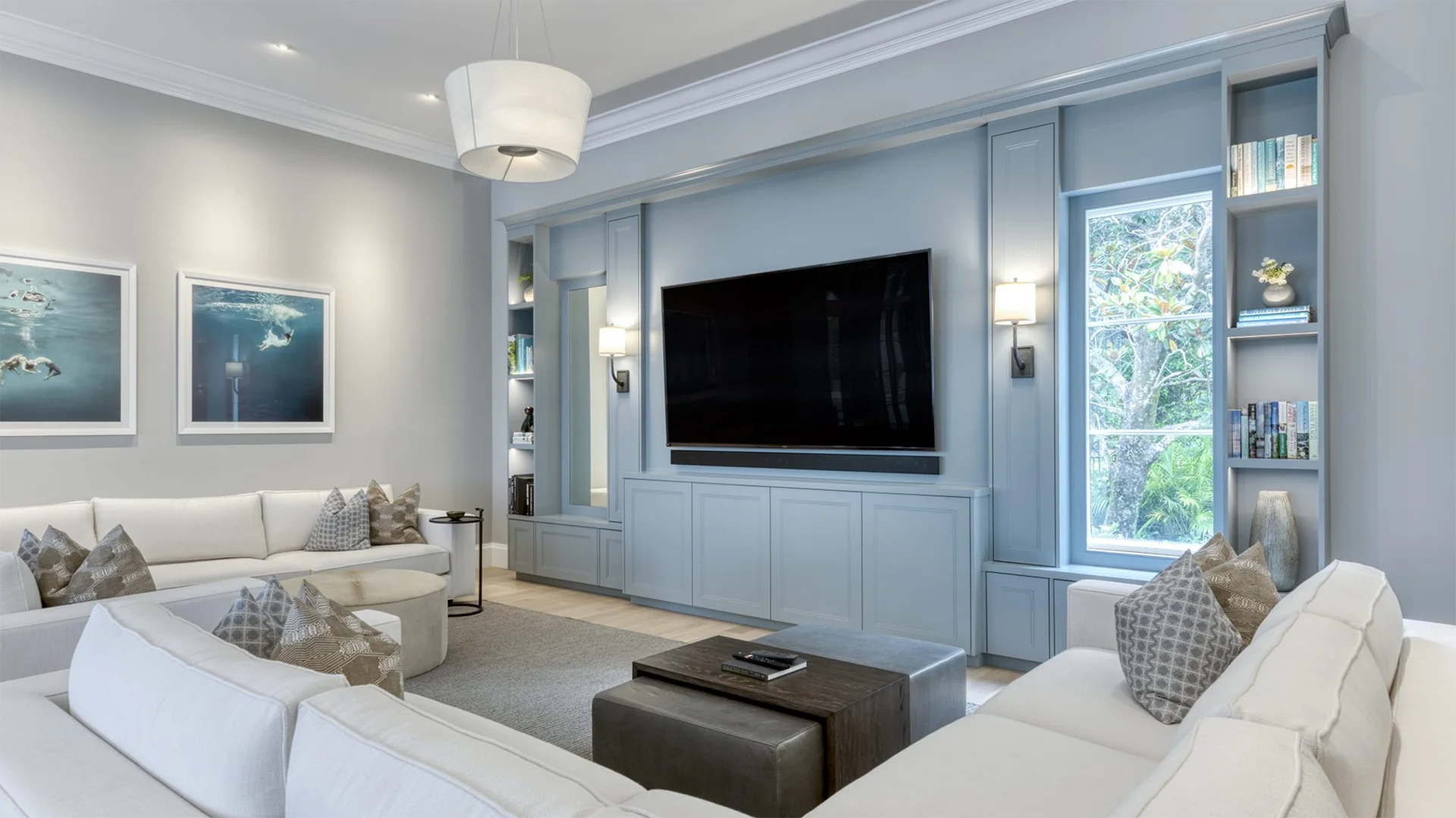Cozy living room adorned with white couches and a flat-screen TV.