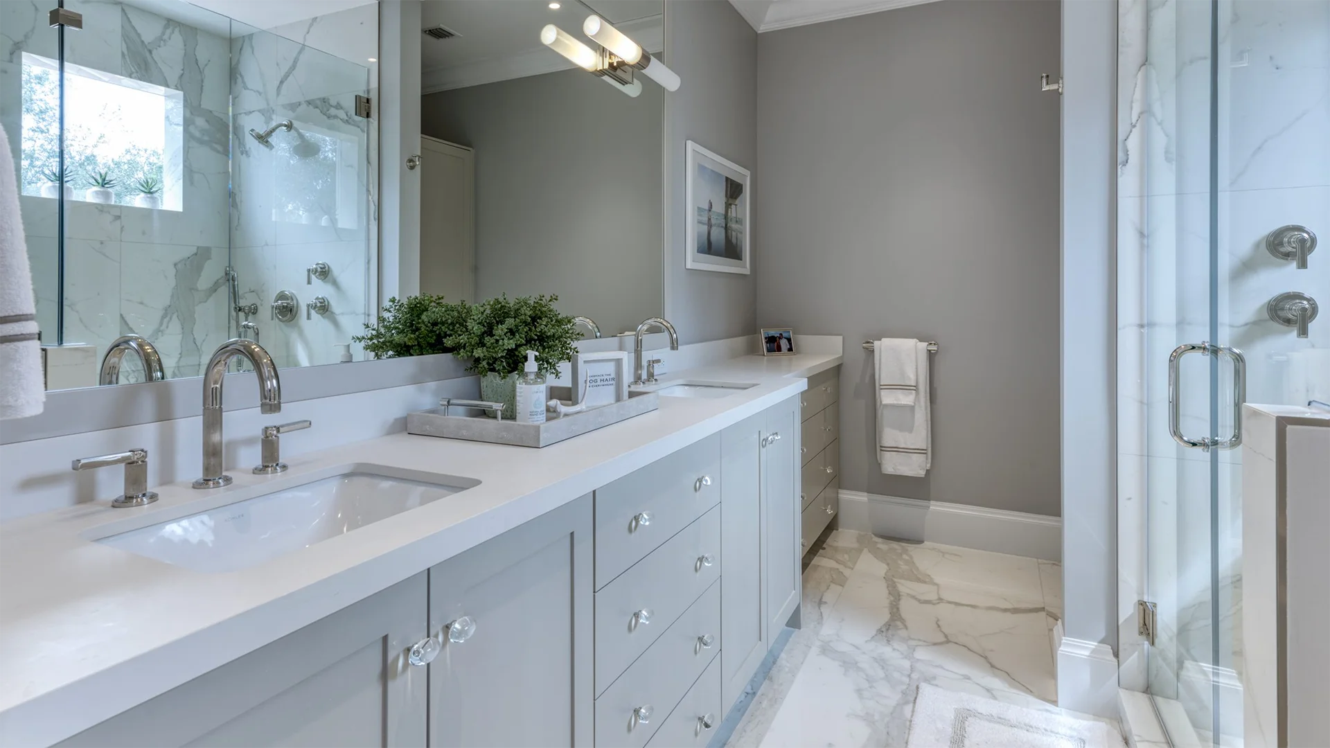 Luxurious bathroom featuring elegant marble countertops and a spacious walk-in shower for a modern aesthetic.