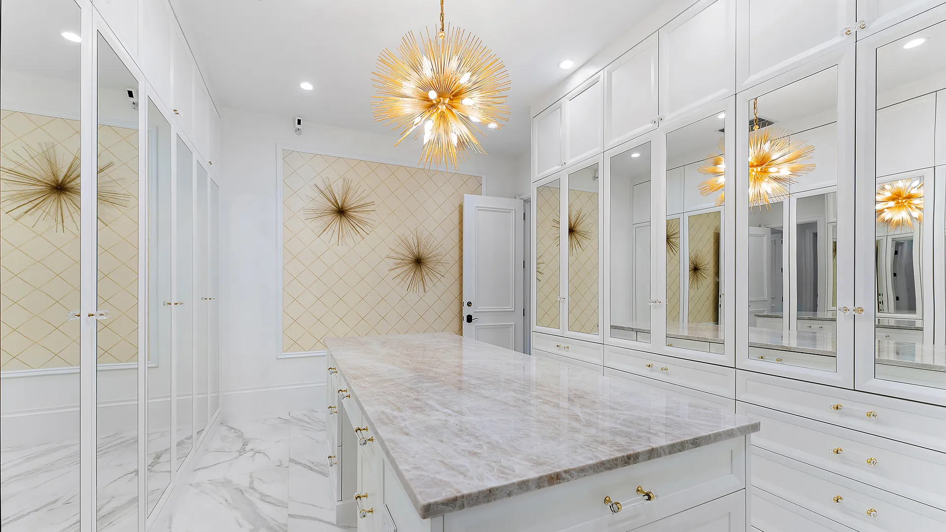 Elegant white walk-in closet with marble countertops.