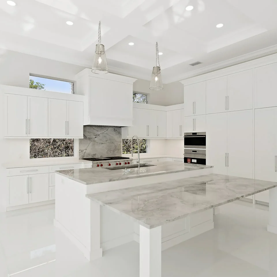 Expansive white kitchen adorned with exquisite marble countertops.