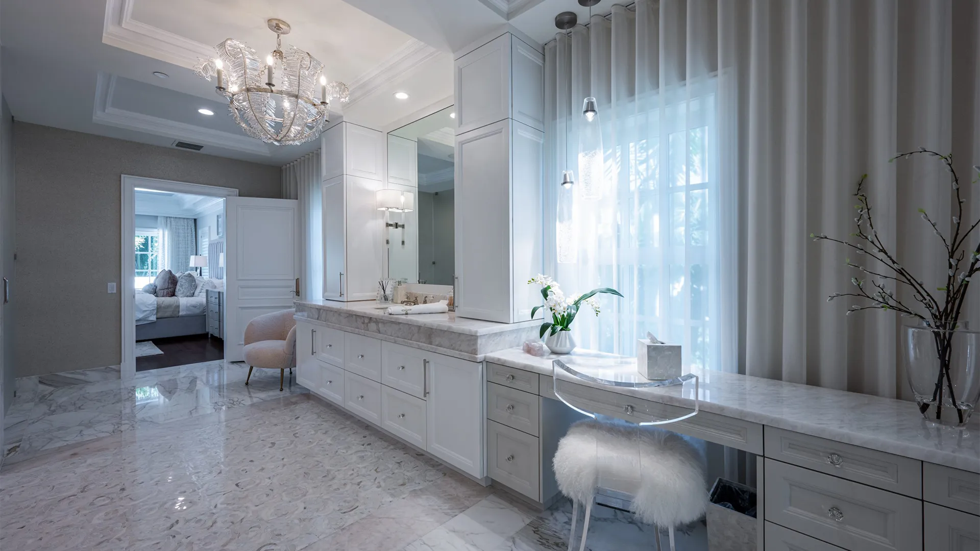 Stylish bathroom accentuated by Dolomite marble countertops and a lovely chandelier.