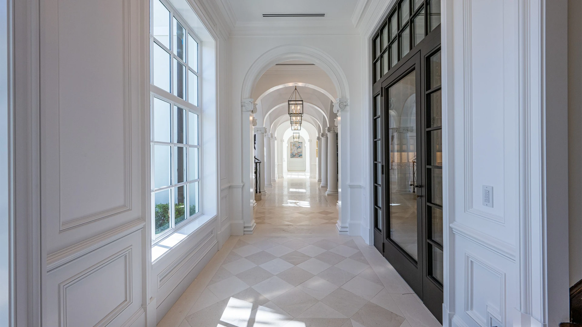 Exquisite hallway featuring immaculate white walls contrasted by sleek black doors, embodying modern elegance.