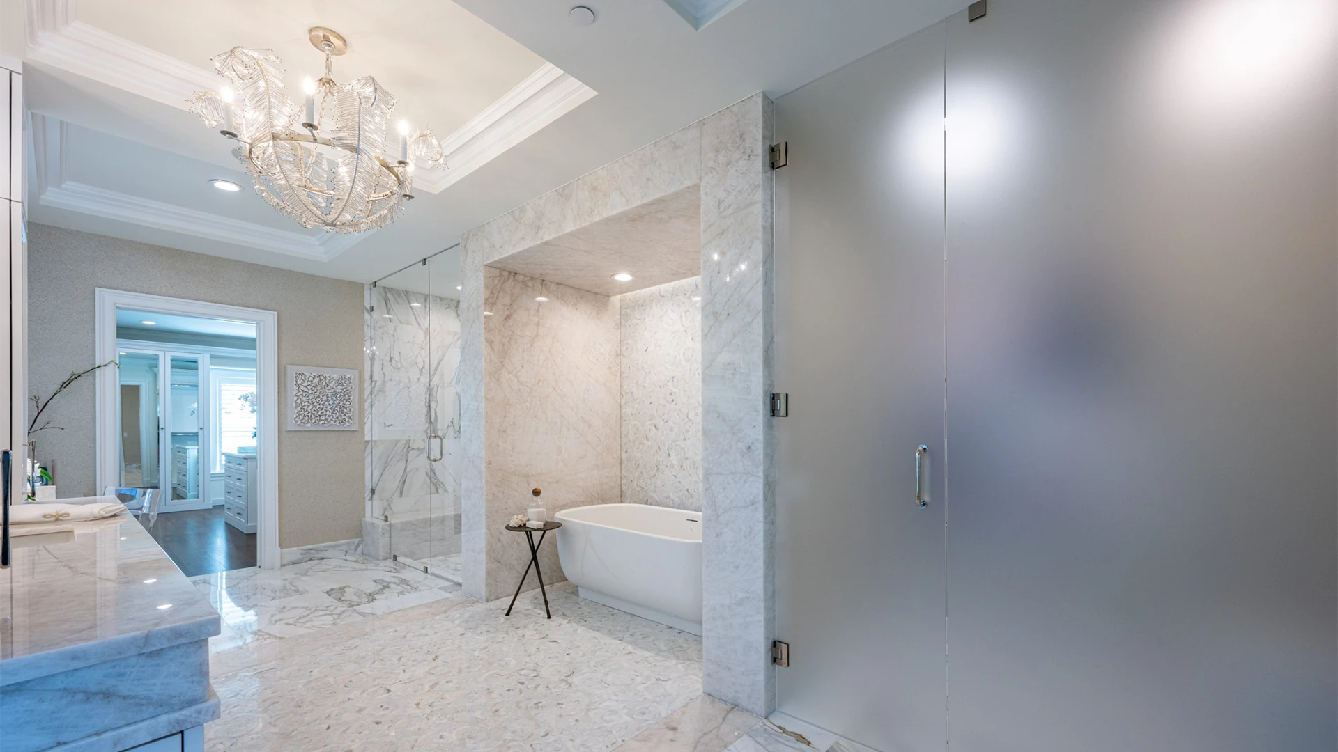 Bright and luxurious bathroom with a spacious tub and a grand gold chandelier.