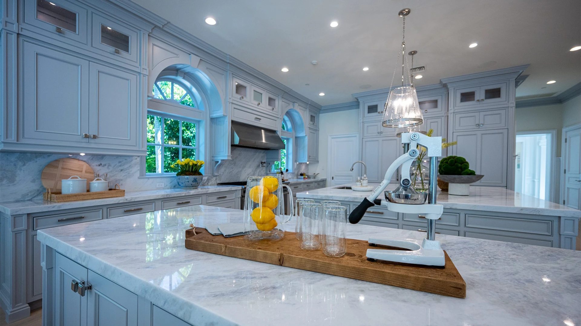 Refined kitchen space boasting marble countertops and blue cabinets, complemented by bright white decorations for an elegant touch.