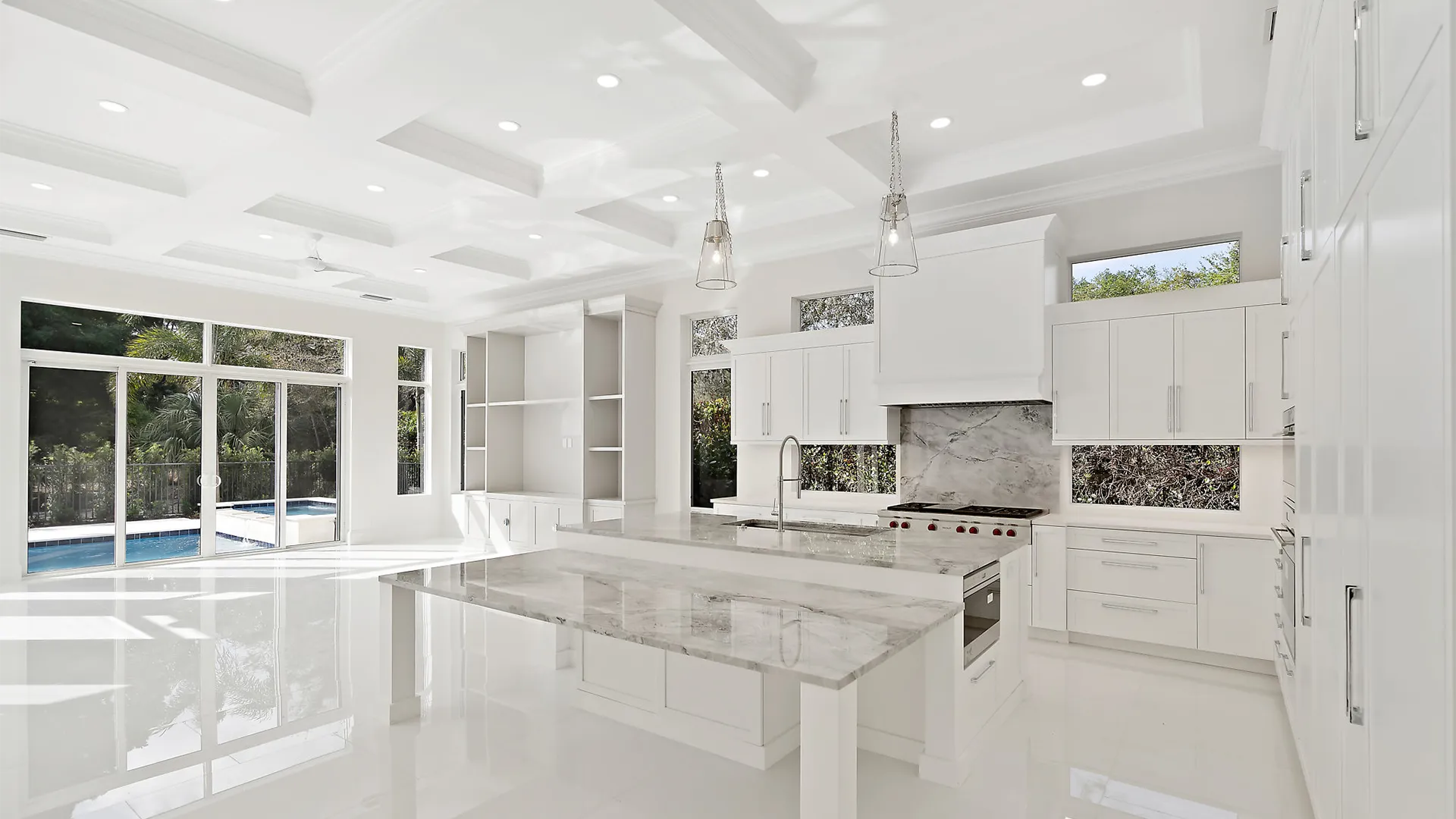 Large and airy kitchen with sleek white finishes and exquisite marble countertops.