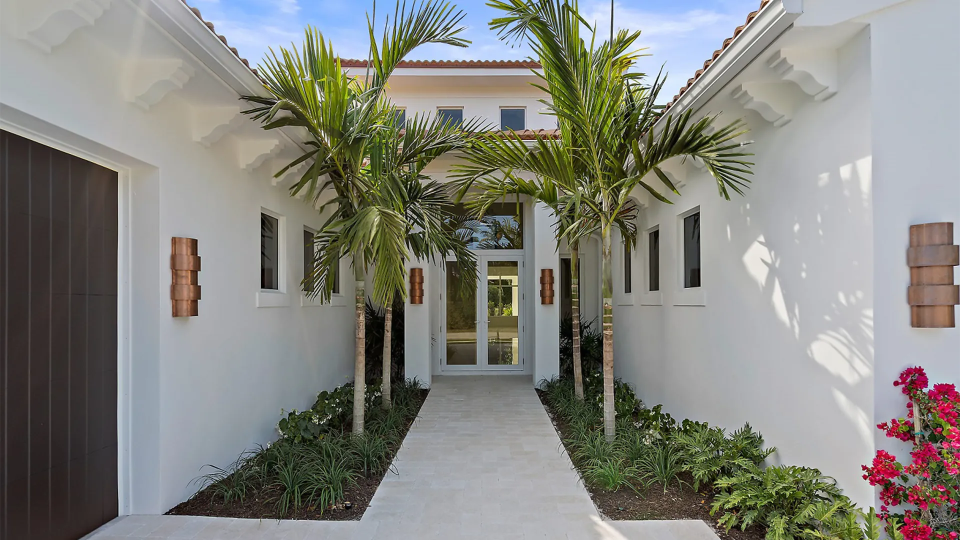 Beautiful pool adds to a Coastal Contemporary style modern home, with palm trees contributing to the peaceful, luxurious atmosphere.