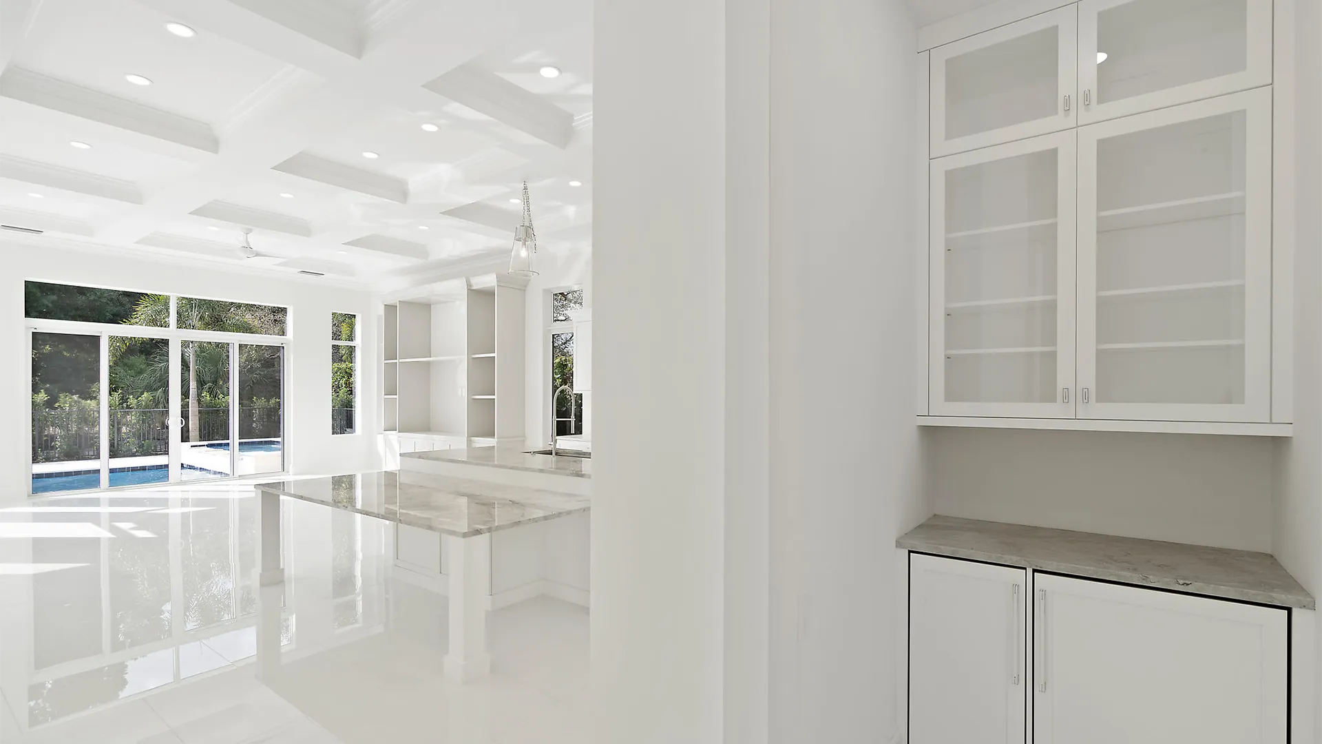Large and airy kitchen with sleek white finishes and exquisite marble countertops.
