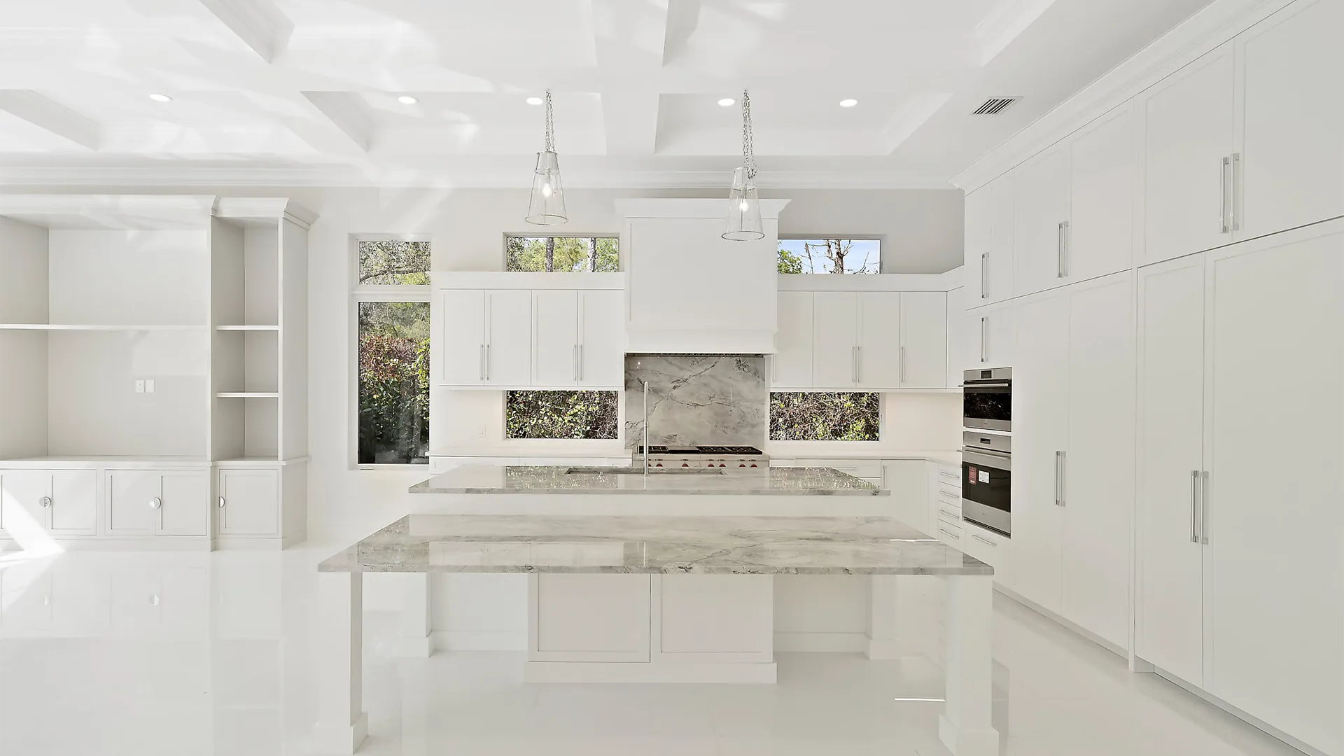 Large and airy kitchen with sleek white finishes and exquisite marble countertops.