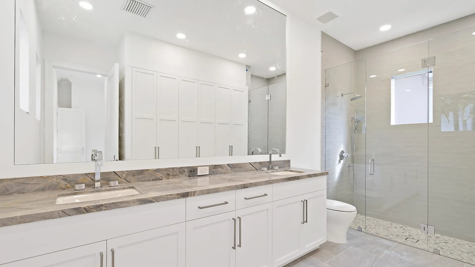 Contemporary bathroom design with a large mirror and a luxurious walk-in shower.