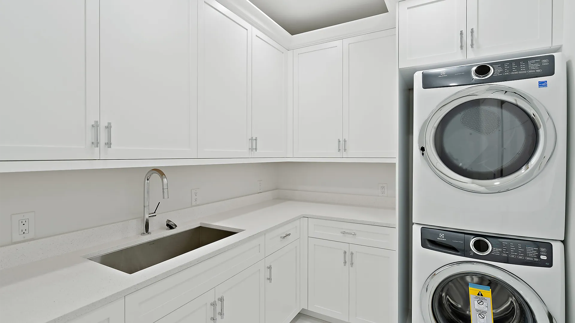 Bright white laundry room featuring a modern washer and dryer, neatly arranged for efficient laundry tasks.