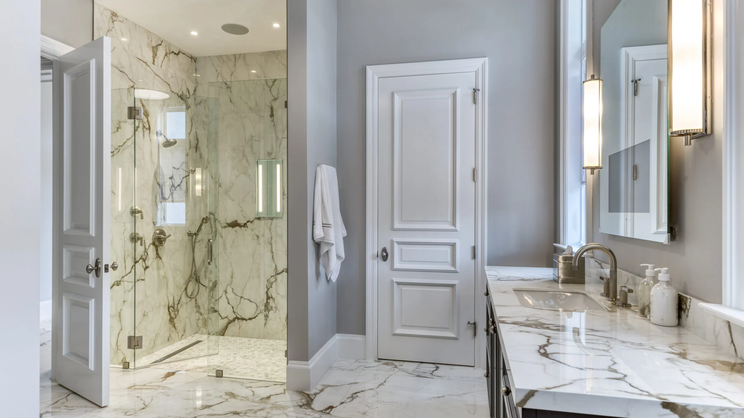 Bathroom featuring elegant marble flooring and pristine white walls.