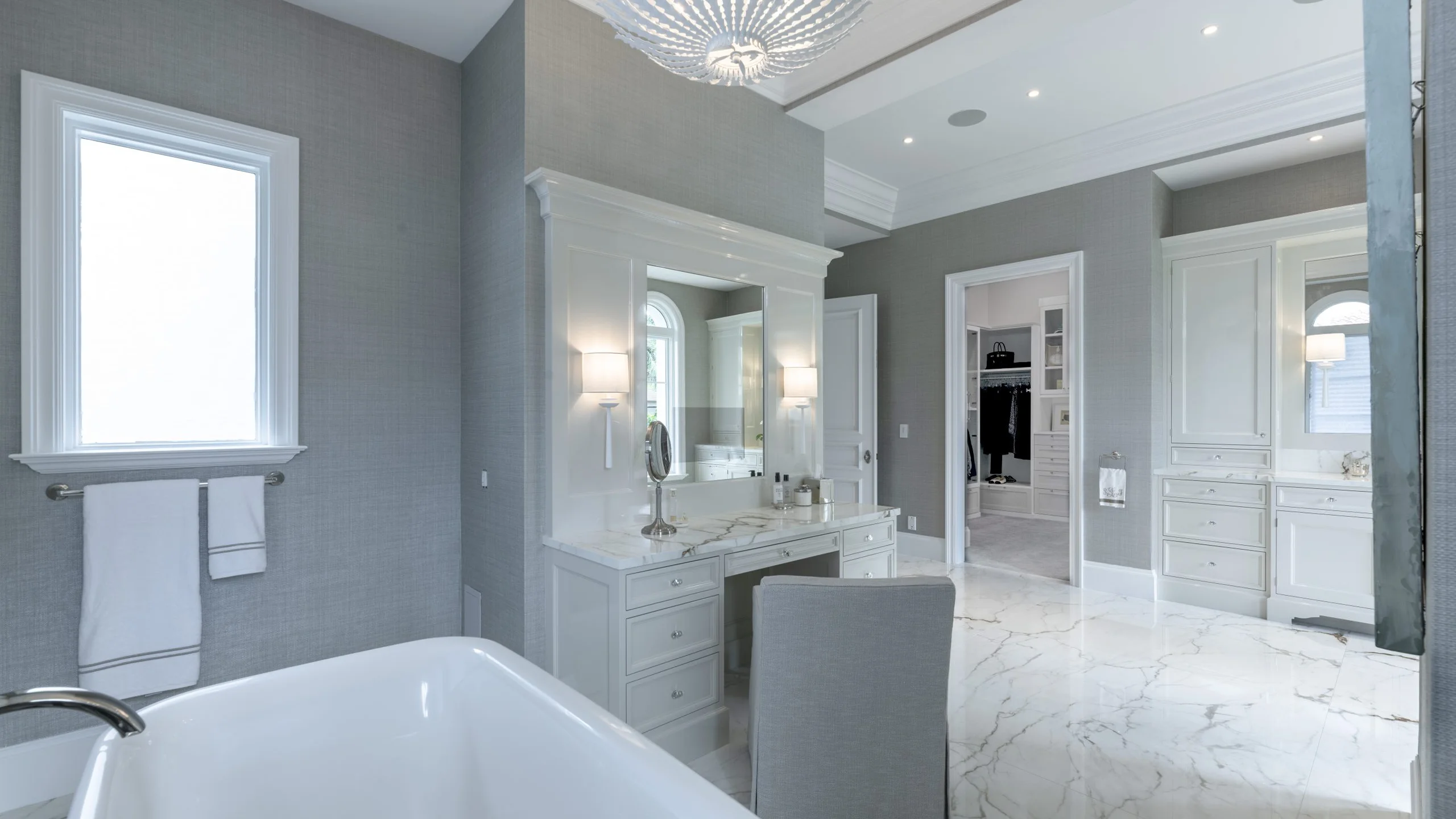 Bathroom featuring elegant marble floors and pristine white fixtures.
