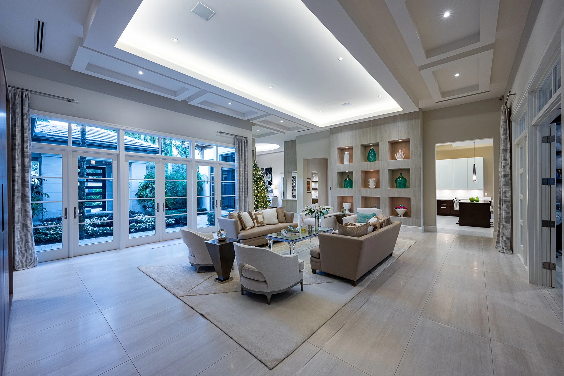 Expansive living room with white windows and wooden floors, highlighted by a stylish ceiling fan for a touch of luxury.
