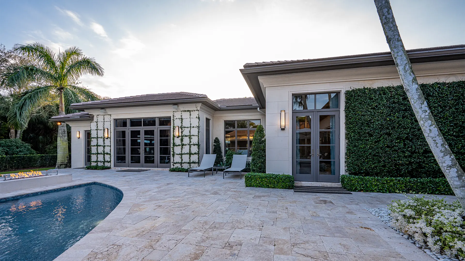 Beautiful poolside oasis with a generous patio, set against a Coastal Contemporary house.