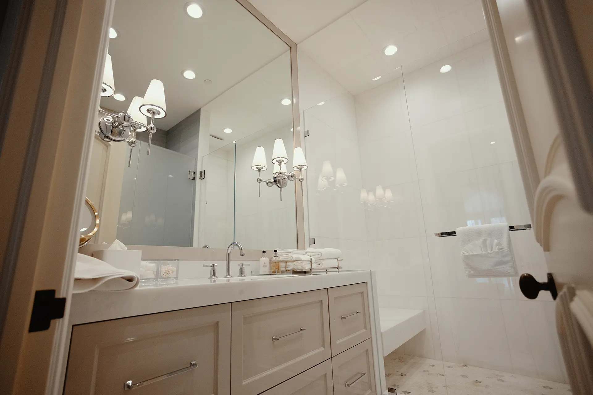 Elegant bathroom featuring High Gloss Lacquer Vanity in Alpaca, a shower, topped by a refined Polished White Diamond Marble with inviting lights.