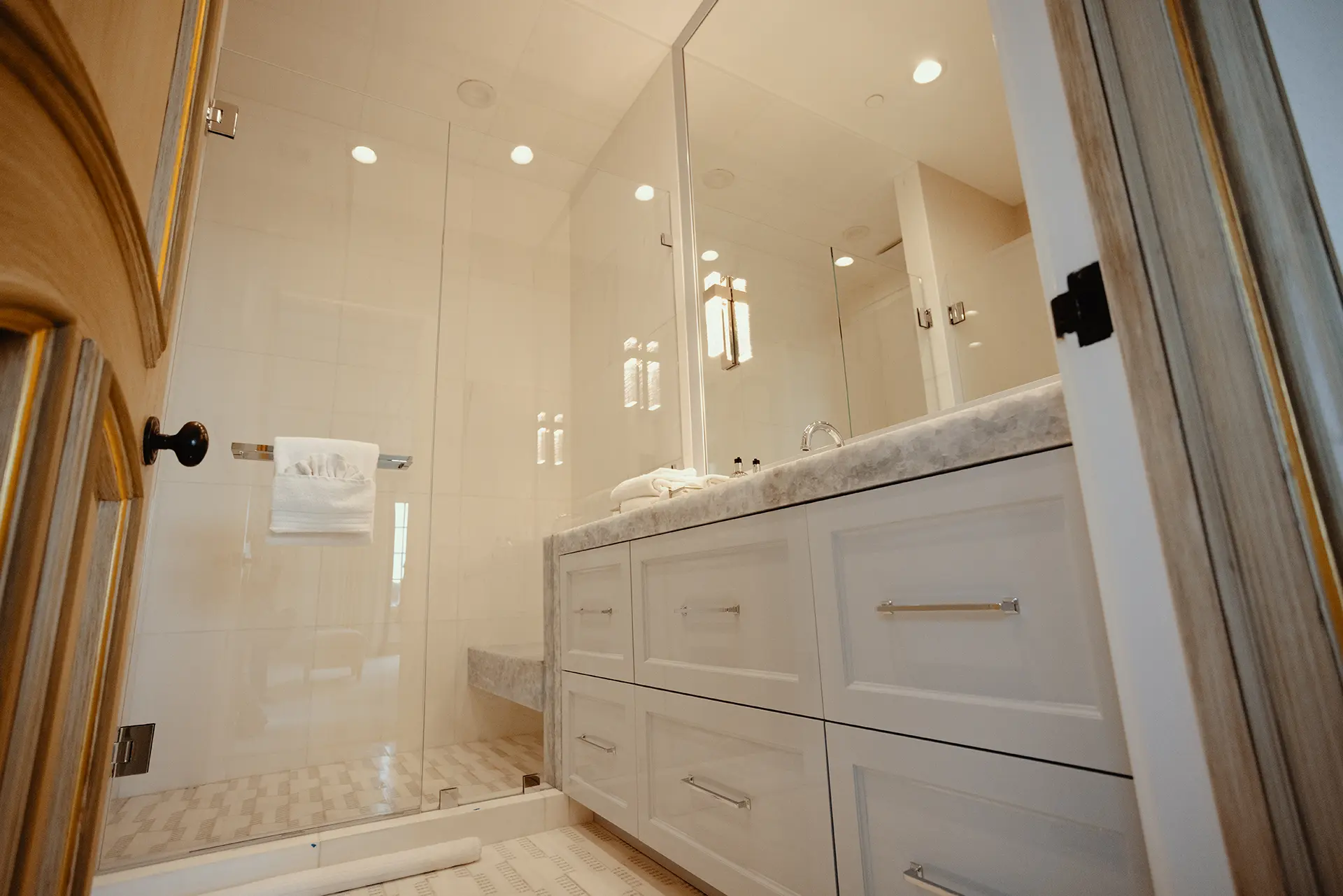 Luxurious bathroom featuring a spacious walk-in shower High Gloss Lacquer Vanity in Iced Slate, topped with Polished Calcite Blue Quartzite, and a Honed Sidetrack Bianco Dolomiti Mosaic flooring