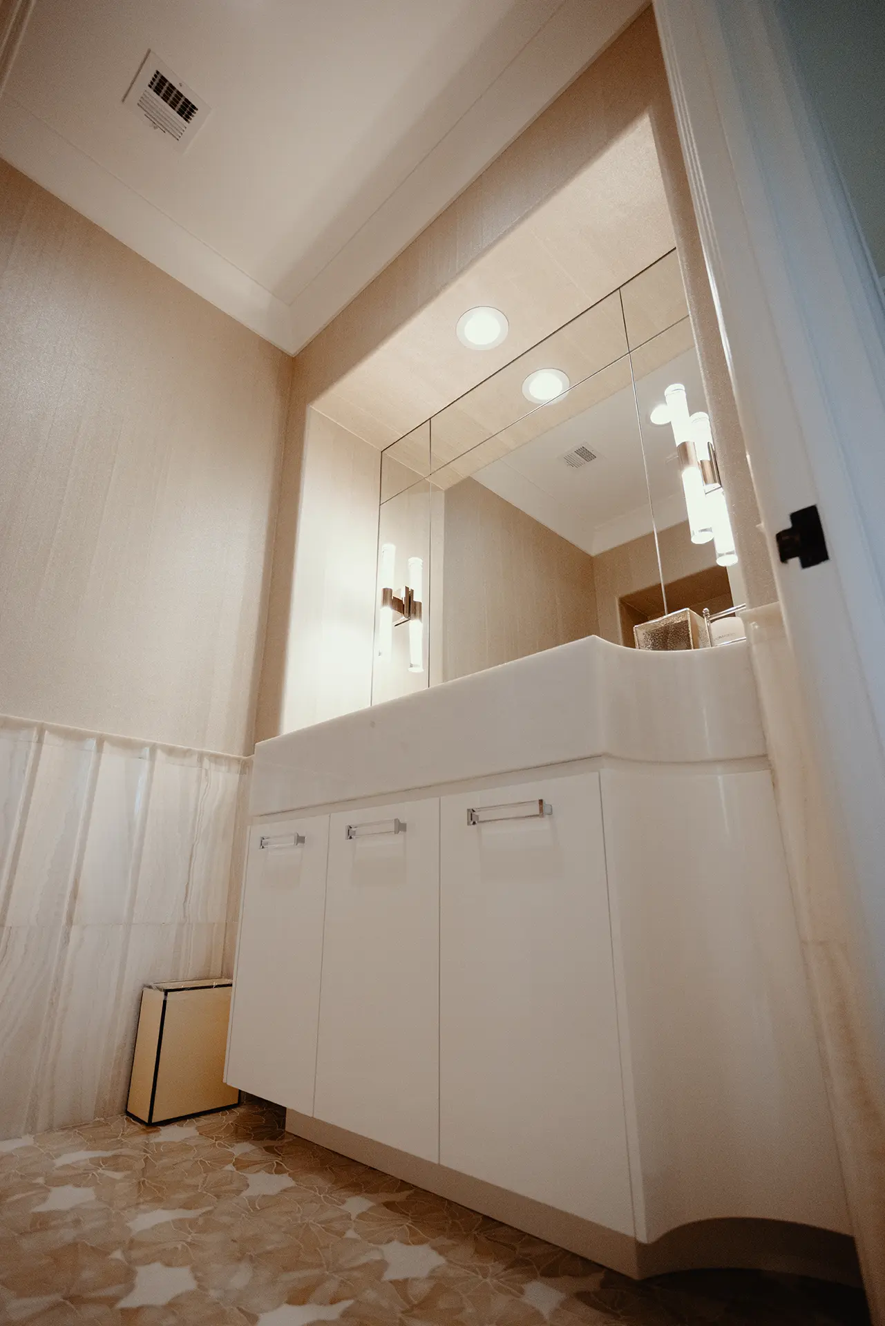 Opulent bathroom design with a custom High Gloss Lacquer Vanity crowned with a 8-inch thick White Thasos Marble slab, with a Walden Bianco Select floor mosaic